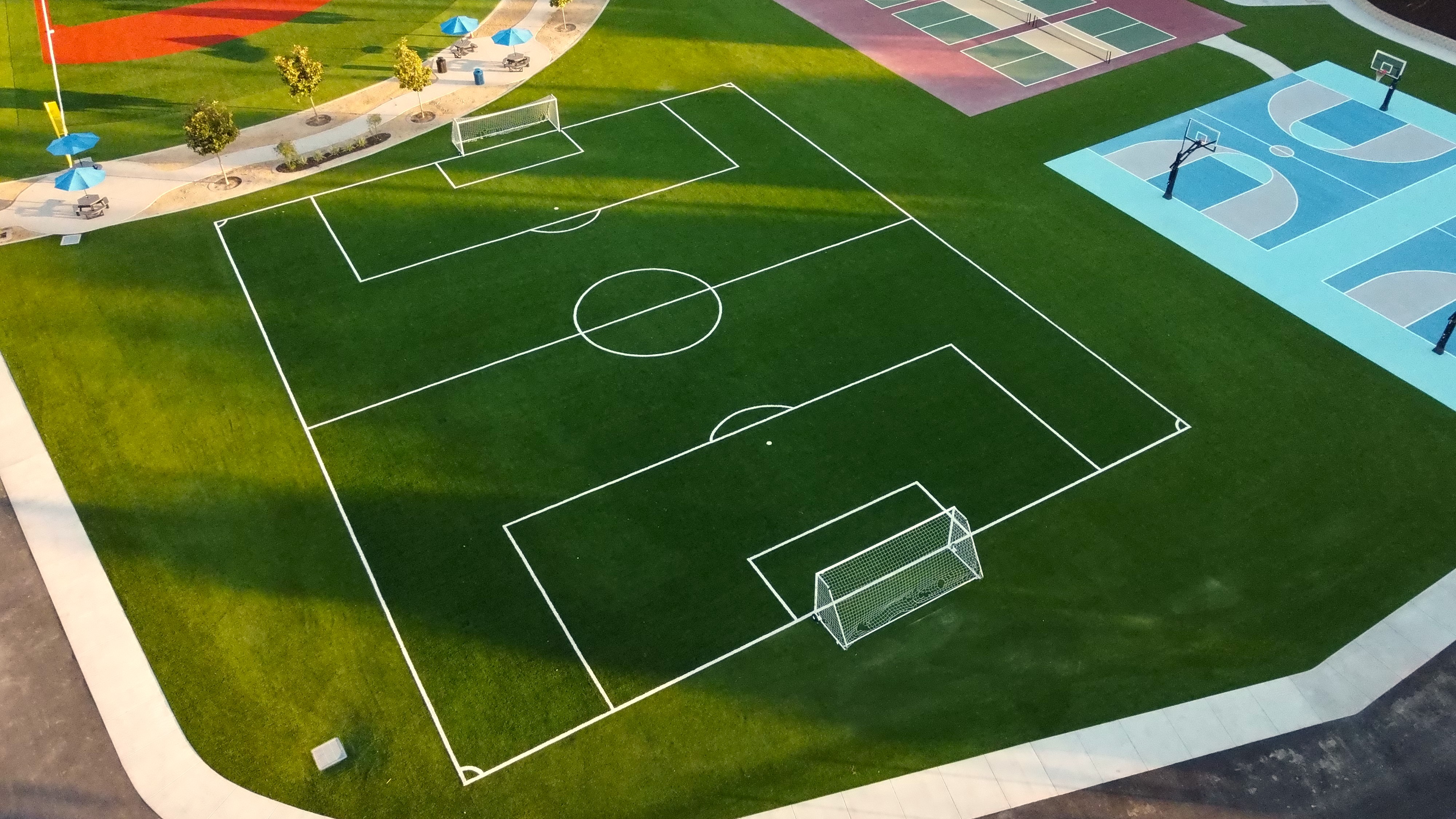 Turf soccer field beside basketball and pickleball courts