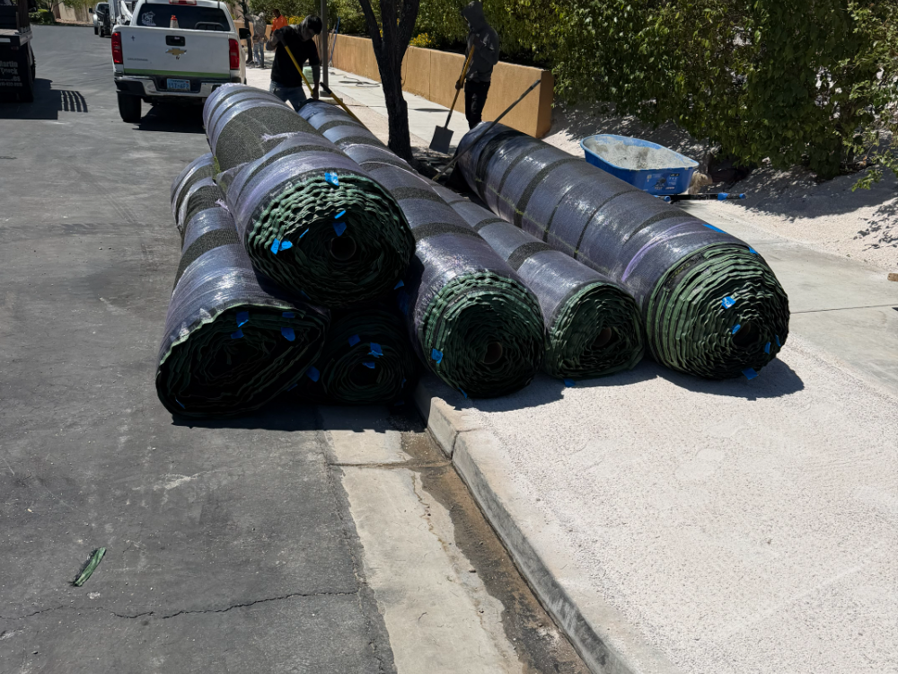 Turf rolls on a job site with every cut marked in blue tape